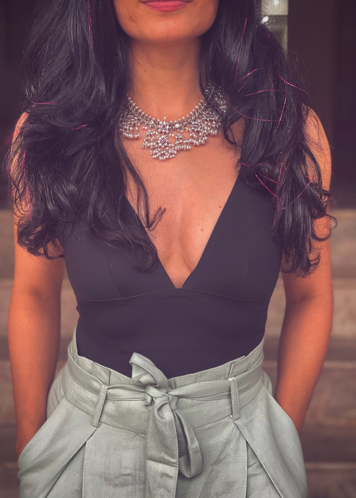 Silver neckpiece with magenta stones and pearls.
