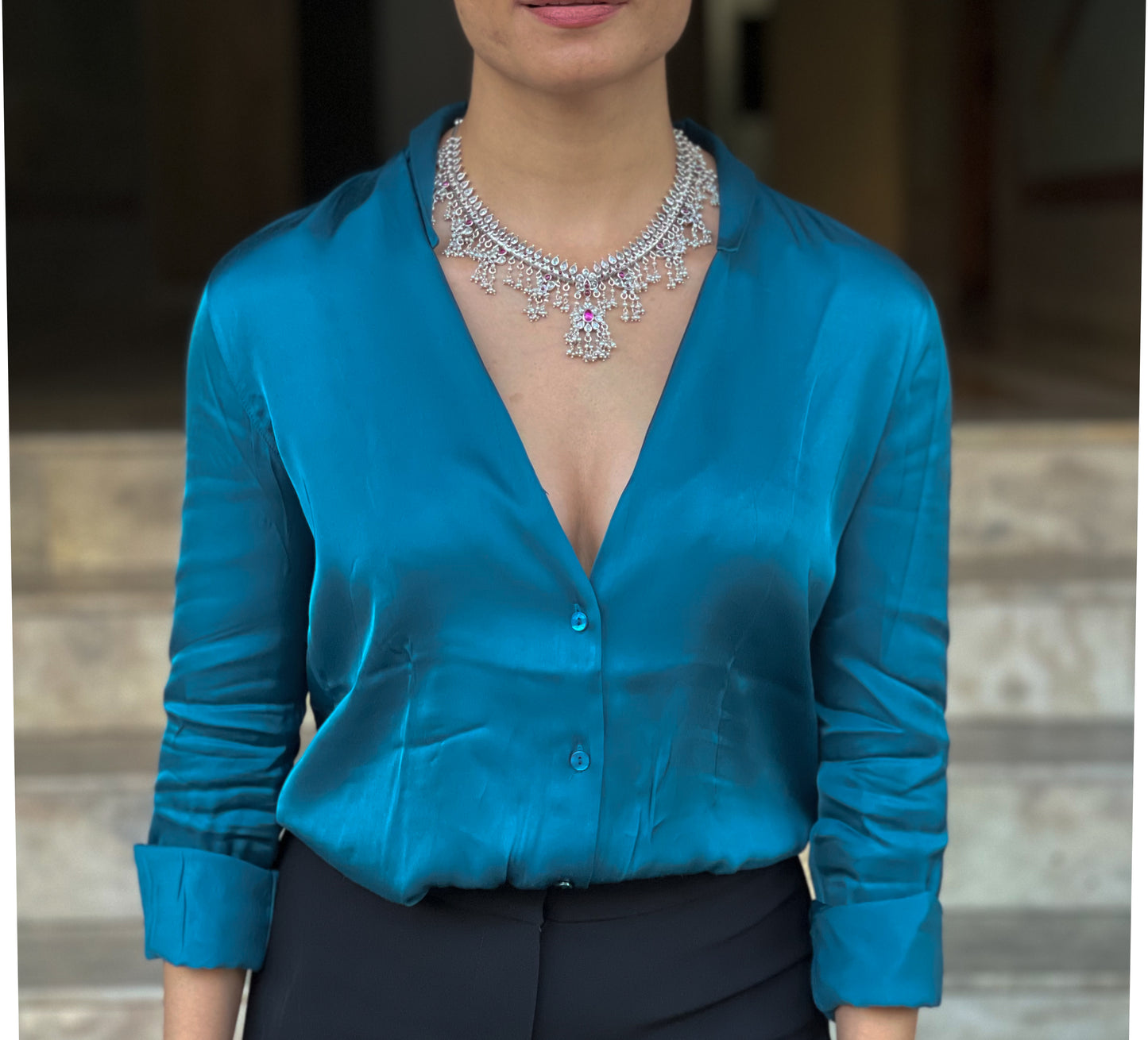 Silver neckpiece with magenta stones and pearls.